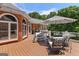Outdoor deck featuring patio furniture, an umbrella, and scenic views of the yard and trees at 660 Milton Dr, Mcdonough, GA 30252
