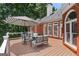 Charming back deck with stylish patio furniture, umbrella, and a view of the surrounding landscape at 660 Milton Dr, Mcdonough, GA 30252