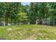 Large backyard featuring mature trees, a playset, and a trampoline for outdoor fun and relaxation at 660 Milton Dr, Mcdonough, GA 30252