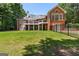 Expansive backyard of a brick home, showcasing a multi-level deck, fenced yard and lush green lawn at 660 Milton Dr, Mcdonough, GA 30252