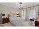 This bedroom features neutral carpeting, natural light, a chandelier, and bright white accents at 660 Milton Dr, Mcdonough, GA 30252