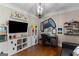 Bright bedroom featuring hardwood floors, neutral walls, stylish light fixture, and built-in storage for decor at 660 Milton Dr, Mcdonough, GA 30252