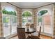 Sun-filled breakfast nook with a round table and views of the outdoors through arched windows at 660 Milton Dr, Mcdonough, GA 30252