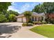 Well-maintained brick home with mature landscaping, a three-car garage, and a circular driveway at 660 Milton Dr, Mcdonough, GA 30252