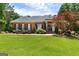 Charming brick home with manicured lawn, mature trees, and well-maintained landscaping at 660 Milton Dr, Mcdonough, GA 30252