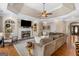 Cozy living room features a fireplace, large sectional sofa, tray ceilings, and neutral decor at 660 Milton Dr, Mcdonough, GA 30252