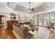 Open-concept living room with tray ceilings, hardwood floors, and a comfortable sectional sofa with ample seating at 660 Milton Dr, Mcdonough, GA 30252