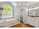 The main bathroom has a garden tub with stone surround, arched window, and a granite-topped vanity at 660 Milton Dr, Mcdonough, GA 30252
