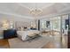 Bright main bedroom with hardwood floors, chandelier lighting, sitting area, and neutral color palette at 660 Milton Dr, Mcdonough, GA 30252