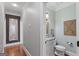 Small powder room with designer mirror, cabinet sink, and hardwood floors at 660 Milton Dr, Mcdonough, GA 30252