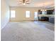 Spacious living room and kitchen combo with carpet, ceiling fan, and three windows at 120 Magnaview Dr, Mcdonough, GA 30253