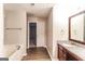 Bathroom featuring granite counters, dark wood cabinetry, a soaking tub, and wood-look plank flooring at 3796 Wolverton Cir, Lithonia, GA 30038