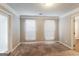 Bedroom with neutral carpet and paint, two windows, and access to an additional room at 3796 Wolverton Cir, Lithonia, GA 30038