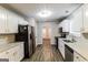 Modern kitchen featuring white cabinets, stainless steel appliances, and hardwood floors at 3796 Wolverton Cir, Lithonia, GA 30038