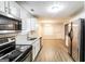Bright kitchen with white cabinets, stainless steel appliances, and hardwood floors at 3796 Wolverton Cir, Lithonia, GA 30038