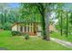 Two-story home featuring a two-car garage, mature trees, and a lush lawn at 6290 Shallowford Way, Douglasville, GA 30135