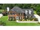 Aerial view of two-story brick home with manicured lawn and mature landscaping at 127 Rockspray Rdg, Peachtree City, GA 30269