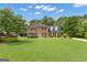 Traditional two-story brick home with a well-manicured lawn and mature trees at 127 Rockspray Rdg, Peachtree City, GA 30269