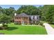 Well maintained two-story brick home featuring mature landscaping and green lawn at 127 Rockspray Rdg, Peachtree City, GA 30269