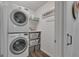 Convenient laundry room with a stacked washer and dryer, storage shelves, and organized space at 127 Rockspray Rdg, Peachtree City, GA 30269