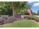 Community sign with the name 'Rockspray', surrounded by colorful shrubs and an American flag at 127 Rockspray Rdg, Peachtree City, GA 30269