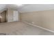 An attic space with neutral carpeting and walls, a bright ceiling fixture, and a door at 409 Brandy Ln, Mcdonough, GA 30253