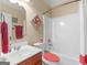 Well-lit bathroom featuring a clean vanity, decorative mirror, toilet and a combined shower and tub at 409 Brandy Ln, Mcdonough, GA 30253