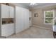 A serene bedroom boasts built-in storage, soft lighting, and a window with a view of lush greenery at 409 Brandy Ln, Mcdonough, GA 30253