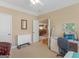 Light-filled bedroom with a view into other rooms, features a desk area and cozy seating at 409 Brandy Ln, Mcdonough, GA 30253
