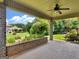 A lovely covered patio with brick columns, a ceiling fan, and a serene view of the manicured backyard at 409 Brandy Ln, Mcdonough, GA 30253