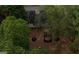 Backyard view highlighting a relaxing firepit area shaded by mature trees, and lush landscaping creating privacy at 70 Summer Walk Dr, Covington, GA 30016