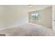 Spacious bedroom with plush carpeting, large window, and neutral walls at 5915 Partners Pass, Cumming, GA 30028