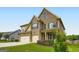 This gorgeous two-story home features stone and siding details with an attached three car garage at 5915 Partners Pass, Cumming, GA 30028