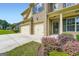 Close-up view of home's entrance and garage, landscaped with green grass and pink flowering bushes at 5915 Partners Pass, Cumming, GA 30028