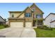Beautiful two-story home featuring a three car garage and a stone and siding exterior with manicured lawn at 5915 Partners Pass, Cumming, GA 30028
