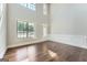 Spacious living room with beautiful hardwood floors and large windows for natural light at 5915 Partners Pass, Cumming, GA 30028