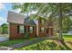 Well-maintained two-story home with a brick facade and a paved walkway, framed by a mature tree at 2326 Sand Dollar Sw Ct, Atlanta, GA 30331