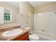 This bathroom offers a tub with tile surround, a neutral countertop, and a window for natural lighting at 4496 Housworth Dr, Lithonia, GA 30038