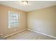 A bright bedroom features neutral carpet, a window for natural light, and is move-in ready at 4496 Housworth Dr, Lithonia, GA 30038