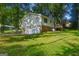 Exterior elevation of the home with a brick foundation, grassy yard, and attached garage at 4496 Housworth Dr, Lithonia, GA 30038