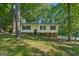 Home exterior featuring a well maintained lawn, dark shutters, and plenty of shade trees at 4496 Housworth Dr, Lithonia, GA 30038