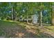 Home exterior surrounded by mature shade trees on a well-maintained lawn and dark shutters at 4496 Housworth Dr, Lithonia, GA 30038