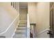 This carpeted staircase with white railings leads to an upper level, offering a functional entryway at 4496 Housworth Dr, Lithonia, GA 30038