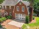 Back exterior view of brick home with a patio, lush landscaping, and plenty of natural light at 1186 Village Ne Cv, Atlanta, GA 30319