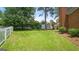 Spacious green backyard with a well-kept lawn, surrounded by a classic white picket fence at 1186 Village Ne Cv, Atlanta, GA 30319