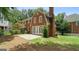Back exterior view with patio, brick, chimney, white trim windows and landscaping at 1186 Village Ne Cv, Atlanta, GA 30319