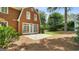 Rear view with patio and French doors to brick home, with a well-kept lawn at 1186 Village Ne Cv, Atlanta, GA 30319