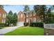 Charming two-story brick home featuring an attached garage, green lawn, and brick pathway at 1186 Village Ne Cv, Atlanta, GA 30319