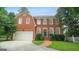 Beautiful two-story brick home with a well-manicured lawn, attached garage, and brick pathway at 1186 Village Ne Cv, Atlanta, GA 30319