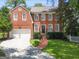 Beautiful red brick home with manicured lawn, mature trees, and a two-car garage at 1186 Village Ne Cv, Atlanta, GA 30319